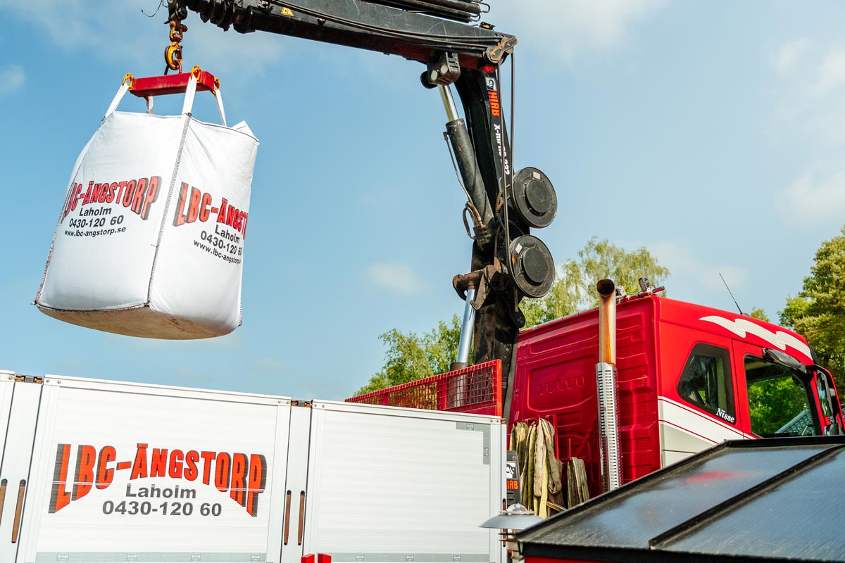 Kran bak på en lastbil lyfter upp en storsäck