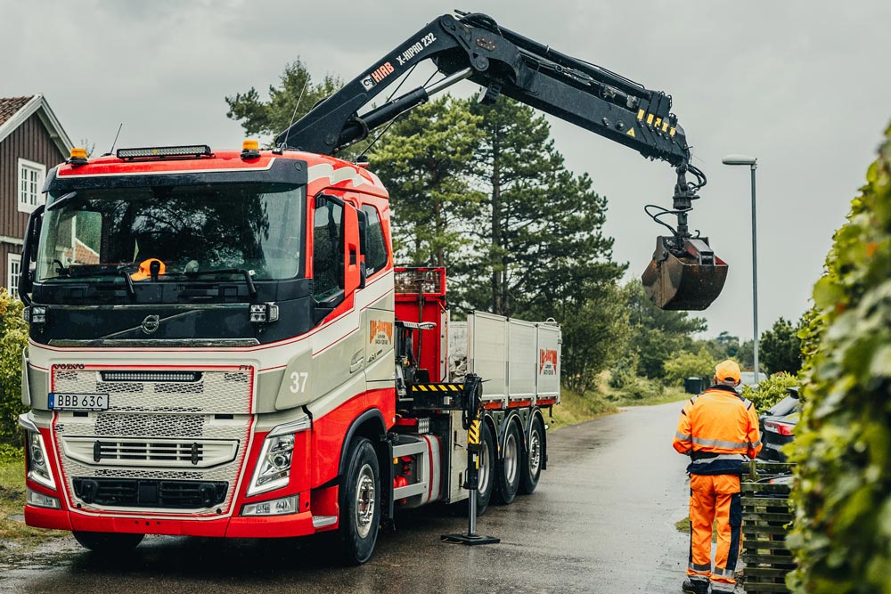 Kranbilstransport på en gata i ett villaområde