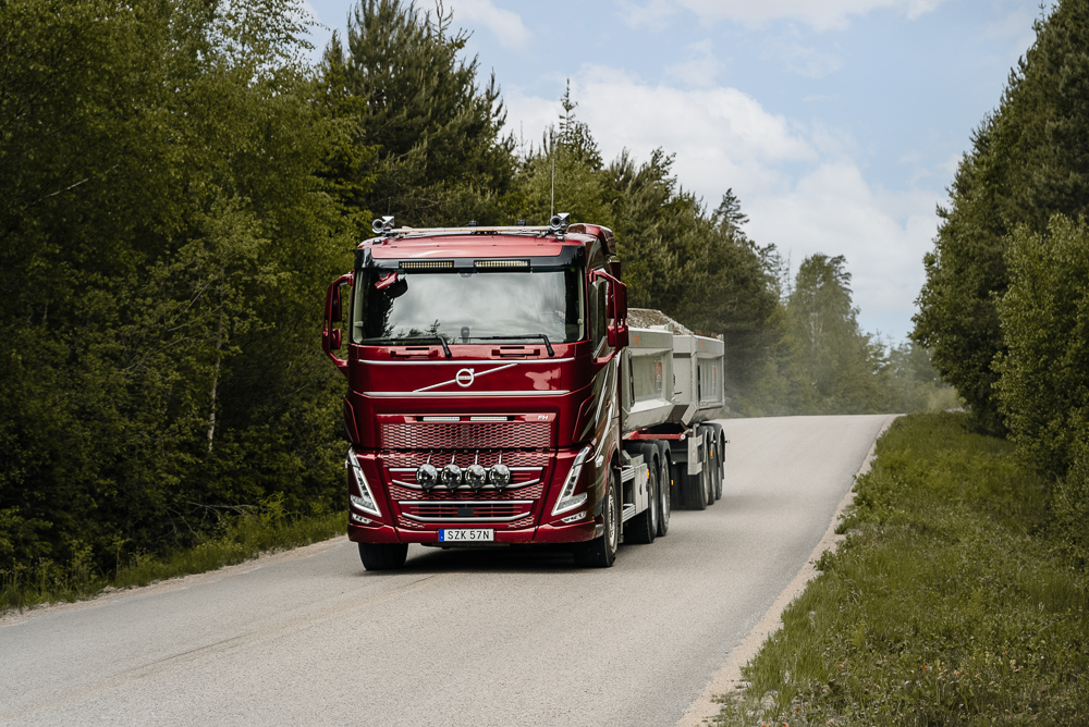 Röd lastbil på en asfalterad äg i skogen
